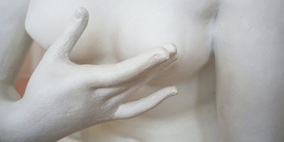 A statue of a woman's torso demonstrating how to check for breast cancer