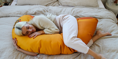 woman hugging a macaroni shaped pillow